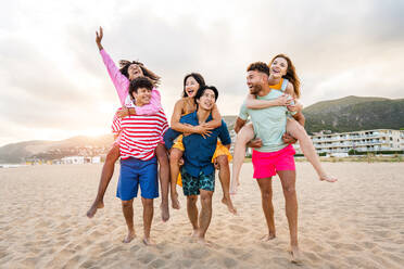 Multiethnic group of young happy friends bonding outside, having fun on summertime vacation - Multicultural cheerful people with summer clothes enjoying summer holidays, concepts about youth, friendship and positive emotion - DMDF03955