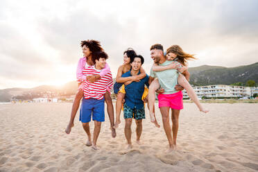 Multiethnic group of young happy friends bonding outside, having fun on summertime vacation - Multicultural cheerful people with summer clothes enjoying summer holidays, concepts about youth, friendship and positive emotion - DMDF03956