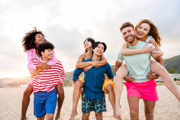 Multiethnic group of young happy friends bonding outside, having fun on summertime vacation - Multicultural cheerful people with summer clothes enjoying summer holidays, concepts about youth, friendship and positive emotion - DMDF03957