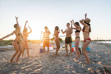 Fröhliche Gruppe von Freunden beim Feiern und Spaß haben am Strand - Junge Leute im Sommerurlaub - DMDF03976