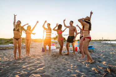 Fröhliche Gruppe von Freunden beim Feiern und Spaß haben am Strand - Junge Leute im Sommerurlaub - DMDF03977