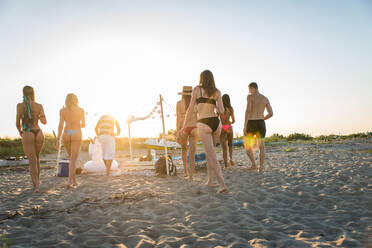 Fröhliche Gruppe von Freunden beim Feiern und Spaß haben am Strand - Junge Leute im Sommerurlaub - DMDF03984