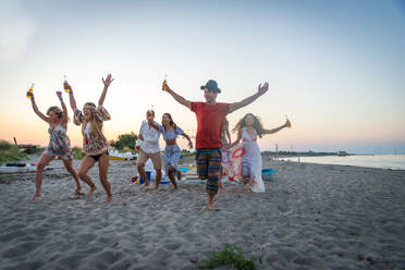 Fröhliche Gruppe von Freunden beim Feiern und Spaß haben am Strand - Junge Leute im Sommerurlaub - DMDF04041