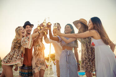 Fröhliche Gruppe von Freunden beim Feiern und Spaß haben am Strand - Junge Leute im Sommerurlaub - DMDF04049