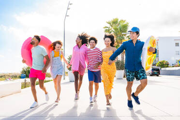 Multiethnic group of young happy friends bonding outside, having fun on summertime vacation - Multicultural cheerful people with summer clothes enjoying summer holidays, concepts about youth, friendship and positive emotion - DMDF04061