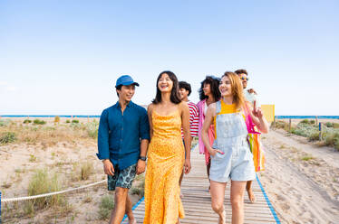 Multiethnic group of young happy friends bonding outside, having fun on summertime vacation - Multicultural cheerful people with summer clothes enjoying summer holidays, concepts about youth, friendship and positive emotion - DMDF04065