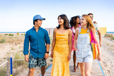 Multiethnic group of young happy friends bonding outside, having fun on summertime vacation - Multicultural cheerful people with summer clothes enjoying summer holidays, concepts about youth, friendship and positive emotion - DMDF04066