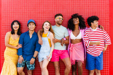 Cheerful friends embracing each other in front of net stock photo