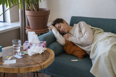 Sick woman resting on sofa at home - VPIF08639