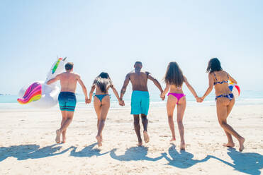 Group of friends having fun on the beach - Young and happy tourists bonding outdoors, enjoying summertime - DMDF04121