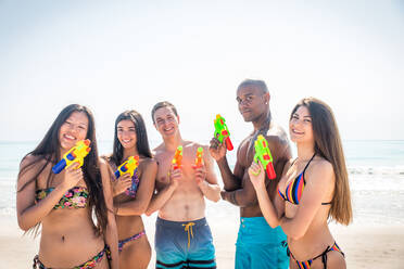 Eine Gruppe von Freunden, die sich am Strand vergnügen - Junge und glückliche Touristen, die sich im Freien treffen und den Sommer genießen - DMDF04129