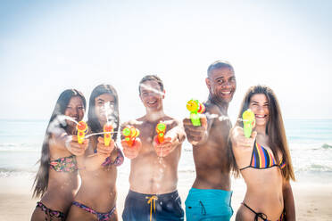 Eine Gruppe von Freunden, die sich am Strand vergnügen - Junge und glückliche Touristen, die sich im Freien treffen und den Sommer genießen - DMDF04132