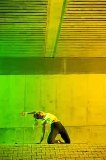 Aktive Frau beim Sport vor einer farbigen Wand - STSF03764