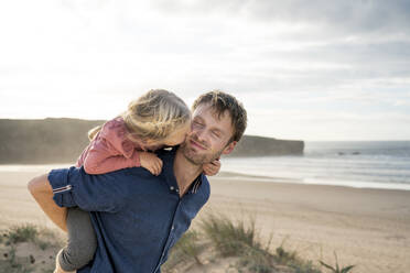 Girl kissing father on cheek at beach - SBOF04026