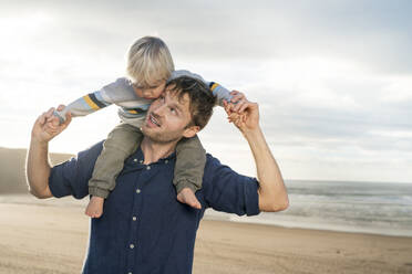 Glücklicher Vater trägt Jungen am Strand auf den Schultern - SBOF04034