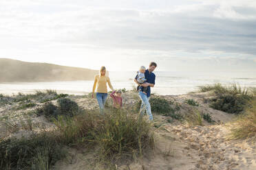 Glückliche Familie beim gemeinsamen Spaziergang am Strand - SBOF04041