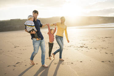 Fröhlicher Vater und Mutter genießen mit Kindern am Strand - SBOF04083