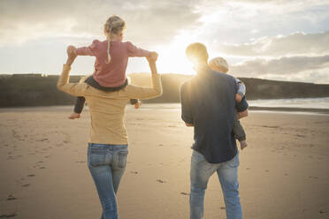 Mutter und Vater gehen mit Kindern am Strand spazieren - SBOF04085