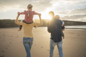 Mutter und Vater gehen mit Kindern am Strand spazieren - SBOF04085