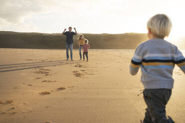 Glückliche Familie spielt zusammen am Strand - SBOF04092