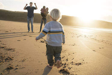 Cheerful family playing together at beach - SBOF04093