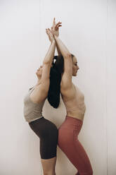 Young women practicing yoga together in studio - KANF00010