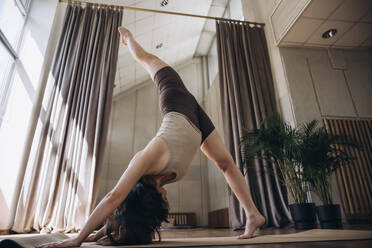 Flexible Frau beim Yoga im Fitnessstudio - KANF00033