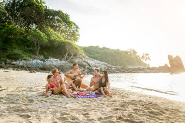 Group of happy friends on a tropical island having fun - Young adults playing together on the beach, summer vacation on a beautiful beach - DMDF04144