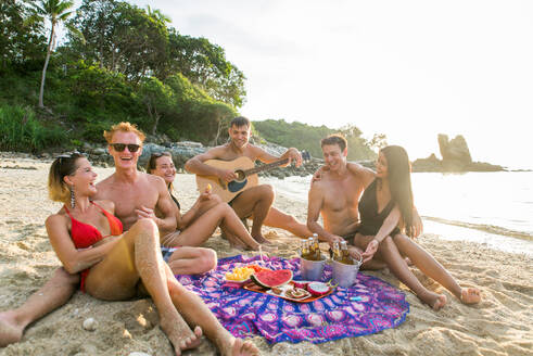 Group of happy friends on a tropical island having fun - Young adults playing together on the beach, summer vacation on a beautiful beach - DMDF04145