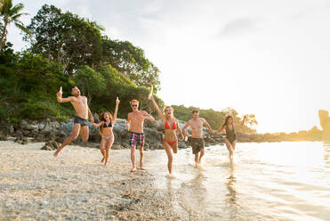 Group of happy friends on a tropical island having fun - Young adults playing together on the beach, summer vacation on a beautiful beach - DMDF04158