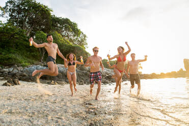 Group of happy friends on a tropical island having fun - Young adults playing together on the beach, summer vacation on a beautiful beach - DMDF04162