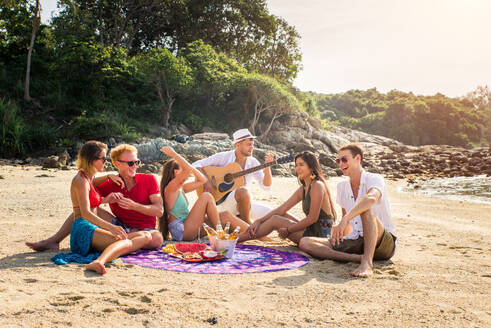 Group of happy friends on a tropical island having fun - Young adults playing together on the beach, summer vacation on a beautiful beach - DMDF04219