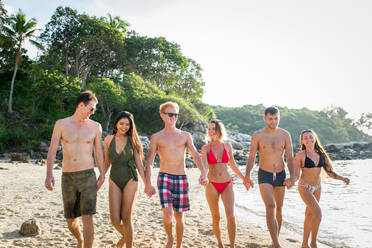 Group of happy friends on a tropical island having fun - Young adults playing together on the beach, summer vacation on a beautiful beach - DMDF04227