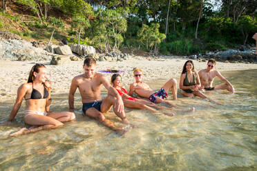 Group of happy friends on a tropical island having fun - Young adults playing together on the beach, summer vacation on a beautiful beach - DMDF04230