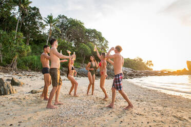 Group of happy friends on a tropical island having fun - Young adults playing together on the beach, summer vacation on a beautiful beach - DMDF04236