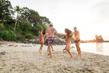 Group of happy friends on a tropical island having fun - Young adults playing together on the beach, summer vacation on a beautiful beach - DMDF04242