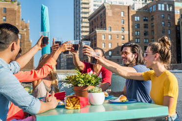 Junge, glückliche Menschen bei einem Grillabend auf einem Dach in New York - Eine Gruppe von Freunden feiert eine Party und hat Spaß - DMDF04255