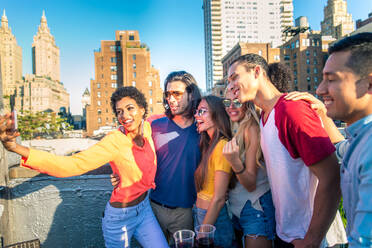 Young happy people having a barbecue dinner on a rooftop in New York - Group of friends having party and having fun - DMDF04264