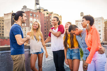 Young happy people having a barbecue dinner on a rooftop in New York - Group of friends having party and having fun - DMDF04281