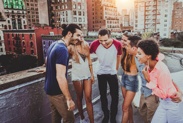 Young happy people having a barbecue dinner on a rooftop in New York - Group of friends having party and having fun - DMDF04282