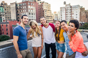 Young happy people having a barbecue dinner on a rooftop in New York - Group of friends having party and having fun - DMDF04283