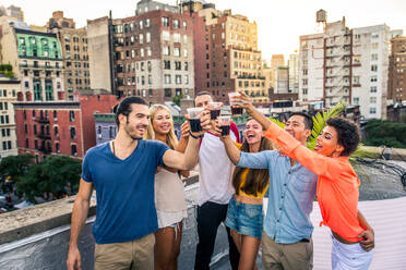 Young happy people having a barbecue dinner on a rooftop in New York - Group of friends having party and having fun - DMDF04284