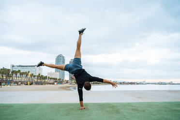 Sportive and athletic man doing functional training exercise at the outdoor gym - Adult athlete doing workout at sunrise at calisthenics park on the beach - Fitness, healthy lifestyle and sport concepts - DMDF04288