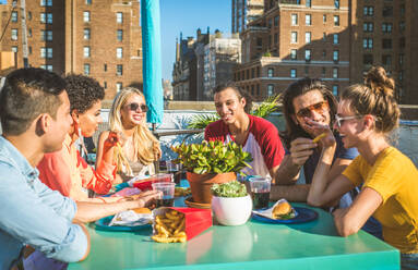 Young happy people having a barbecue dinner on a rooftop in New York - Group of friends having party and having fun - DMDF04293