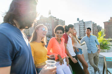 Young happy people having a barbecue dinner on a rooftop in New York - Group of friends having party and having fun - DMDF04311