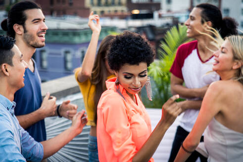 Young happy people having a barbecue dinner on a rooftop in New York - Group of friends having party and having fun - DMDF04327