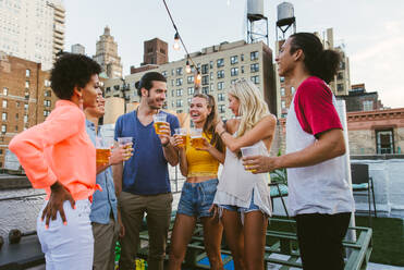 Young happy people having a barbecue dinner on a rooftop in New York - Group of friends having party and having fun - DMDF04349