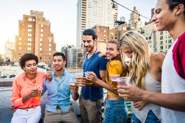 Young happy people having a barbecue dinner on a rooftop in New York - Group of friends having party and having fun - DMDF04351