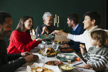 Eine glückliche Familie genießt das Weihnachtsessen zu Hause - EBSF03777