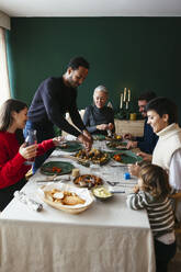 Gemischtrassige Familie beim gemeinsamen Abendessen am Esstisch - EBSF03784